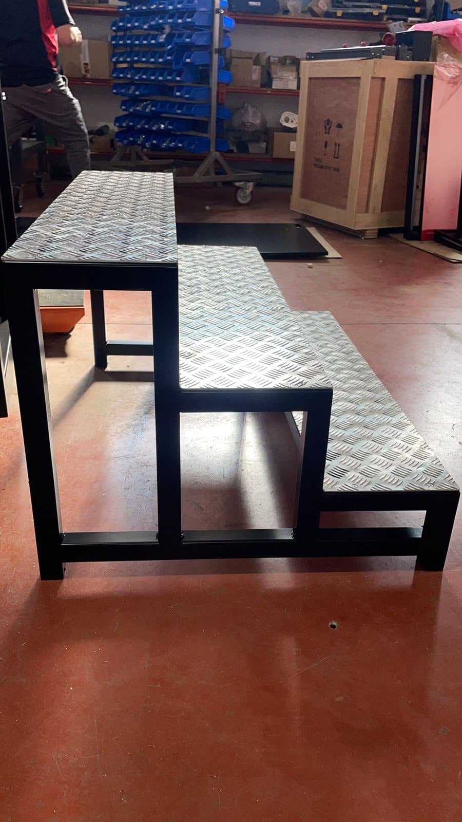 Escalera de tres peldaños con estructura negra y chapa lagrimada