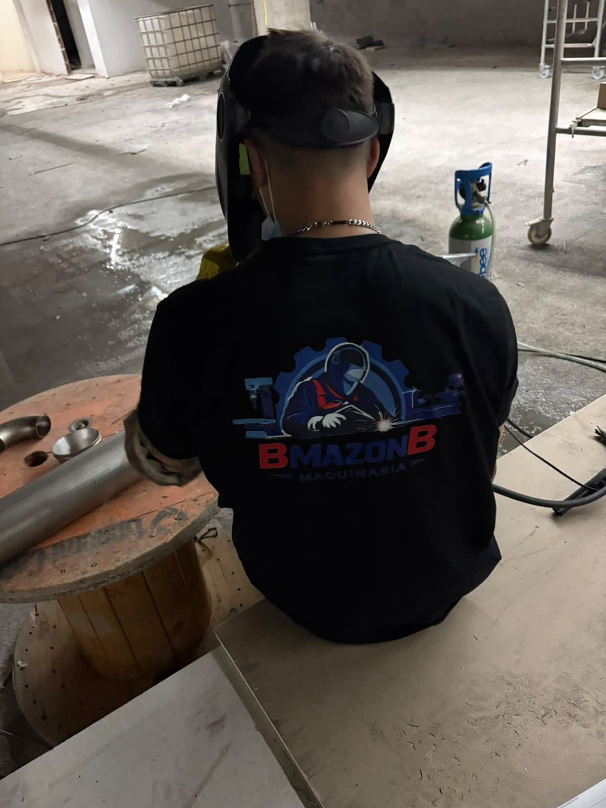 Borja con el logo de BMAZONB en la camiseta, preparando una soldadura en obra