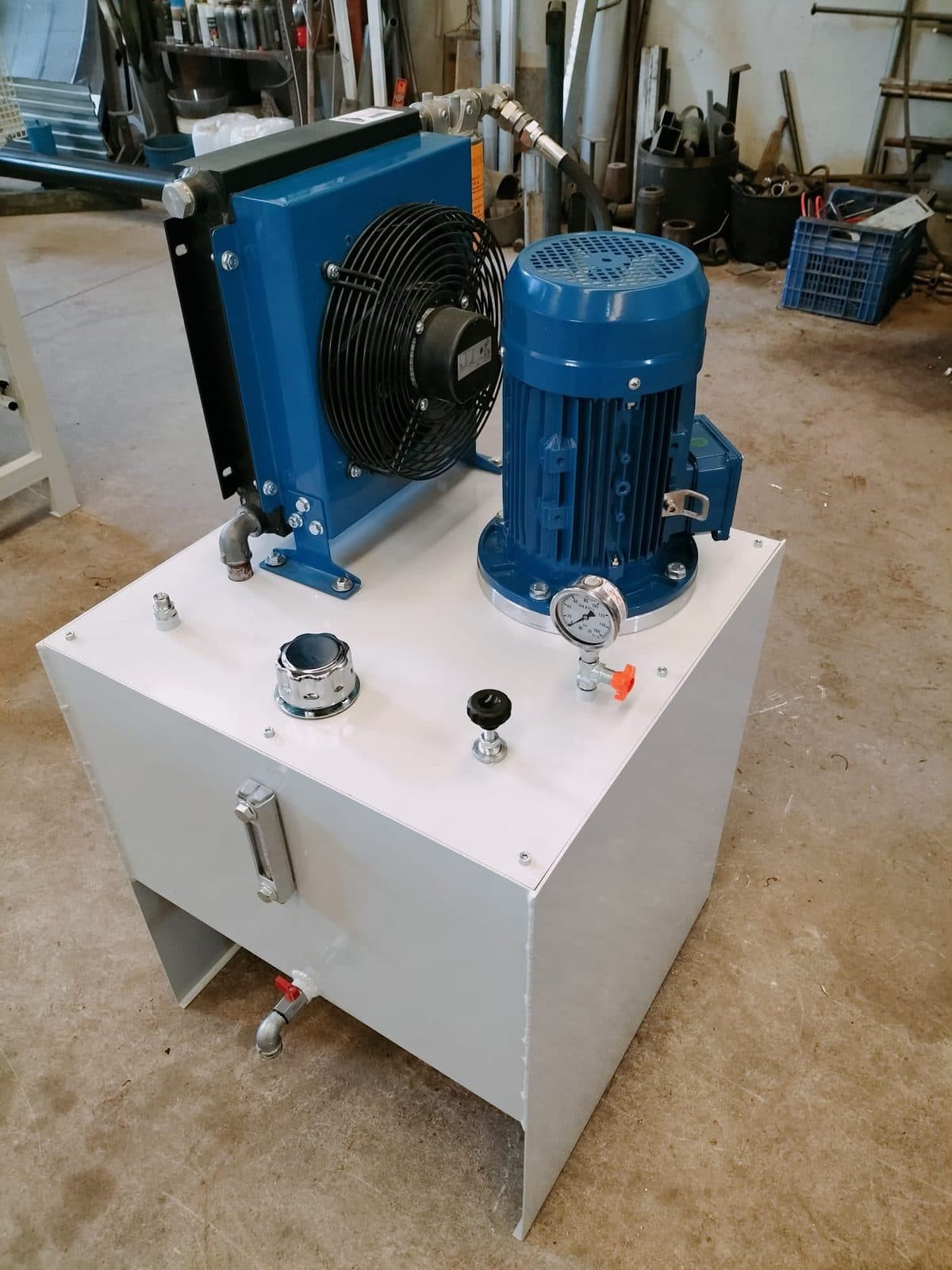 Central hidráulica con depósito blanco, motor eléctrico, enfriador de aceite con ventilador y manómetro